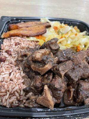 Oxtails, rice and peas, steamed cabbage and plantains
