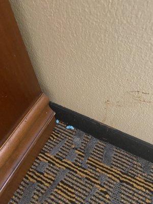 Gum on floor and stain on wall from a few 100 guest ago