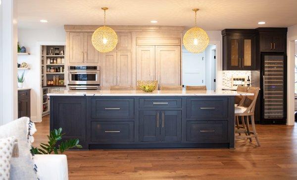 Large island, two-toned cabinetry, and built-in refrigerator