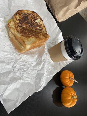 Breakfast items sausage, egg and cheese sandwich with a hot chocolate