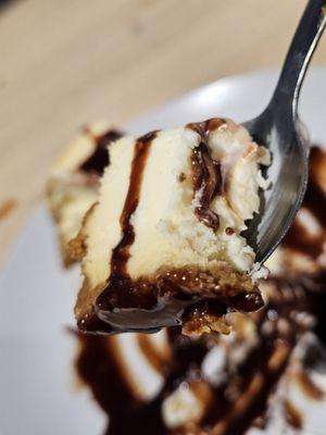 Close-up of a spoonful of the Cheesecake with chocolate syrup.