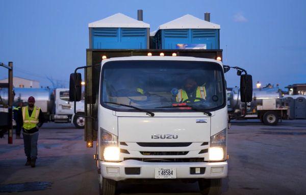 Service technician on his way to drop off portable toilet units