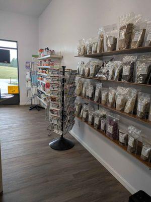 View of bulk herb bags on shelves, with a literature rack, and a workout product shelf in the back.