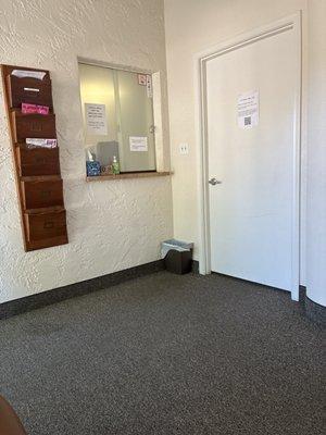 Check in window. Small office and waiting area. Clean and organized.
