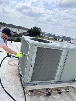 The team washing an ac unit on top of a roof as part of maintenance!