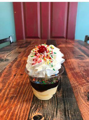 A delicious Country Style sundae with sprinkles and a cherry on top.