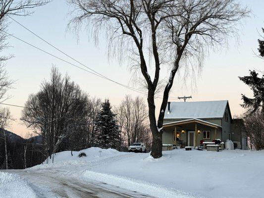 Magical winter light surrounds Stillman House. Inside is wood stove, modern heat, pure comfort. AWD recommended for snowy Adirondack stays.