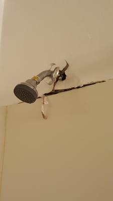 Horrible shower with broken shower head.