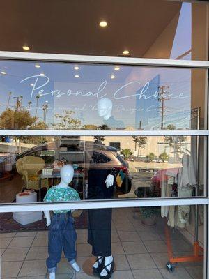 Display window with Personal Choice sign and two clothes mannequins - one adult and one child.