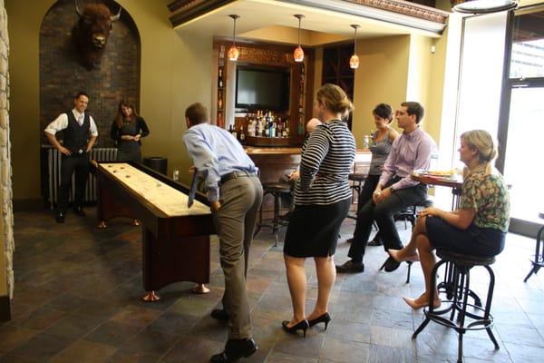 A shuffleboard table adds an element of fun to The Meeting Spot's casual pub area.