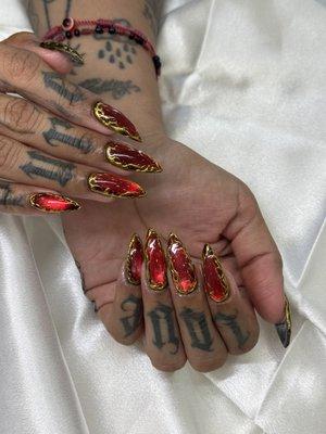 bloody cateye nails with a hint of gold outline on gel x nails