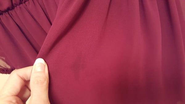 Small dark mark just to the left of center. 4 more spots on the dress similar to that.