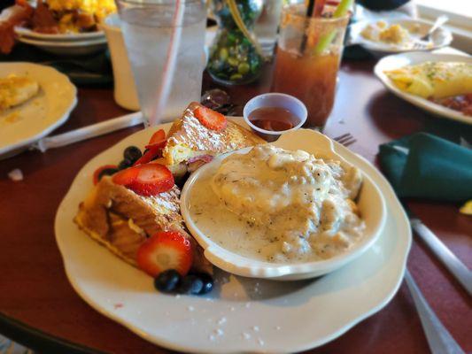 Stuffed French toast with a side of a biscuit with sausage and gravy