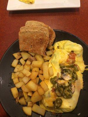 Garden omelette with jalapeños, home style potatoes, and rye toast.