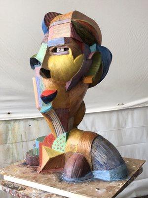 Cubist sculpture of a woman built of wooden sticks and plaster, painted with acrylic paint. 24"x17"x14"