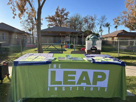 The LEAP Institute table with flyers in front of the children's playground in Mecca