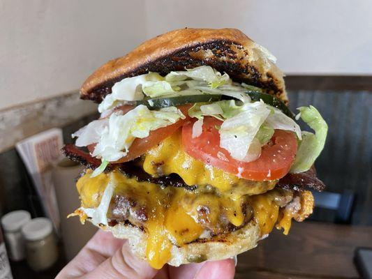 Me hand modeling the extraordinary prime brisket burger. Mine has double beef, bacon, and double cheese. I'm crying out for help.