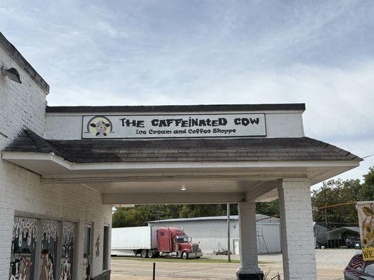 sign posted at top of old gas station canopy