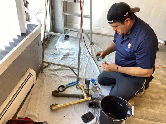 Plumber Javier working on a pipe repair.