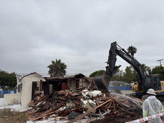 Processing construction debris while performing dust control.