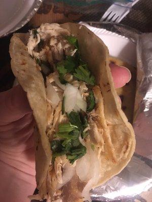 Chicken taco with carnitas and queso pupusa in the background