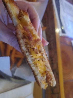 Cross section of grilled cheese with added bacon.