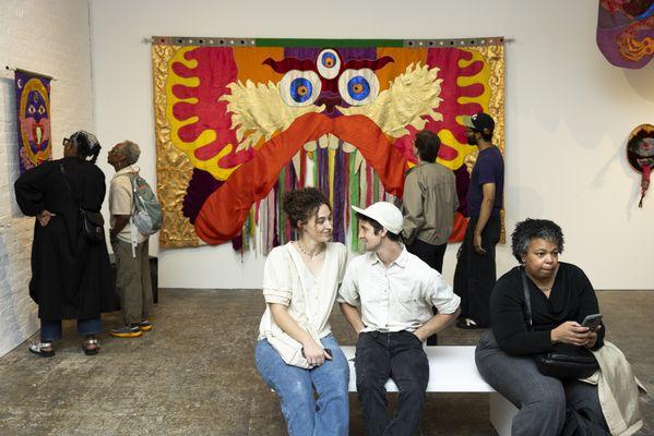 Visitors enjoy the tapestries featured in "The Living Temple: The World of Moki Cherry"