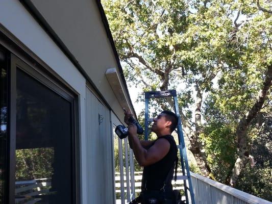 Installing wooden wedge to allow for adequate gutter installation
