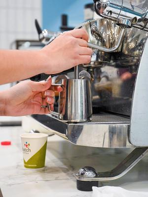 Barista steaming milk for latte.