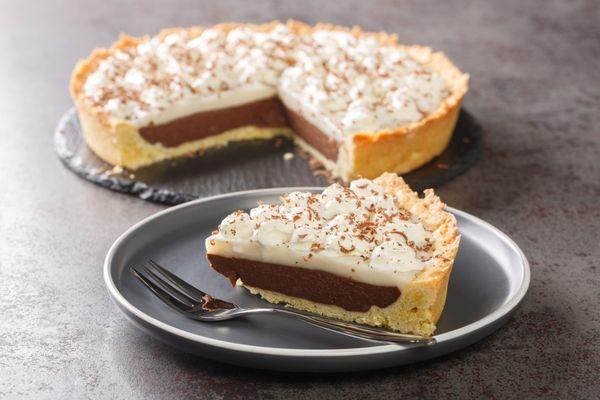 A perfect slice of our rich, creamy coconut pie topped with whipped cream -- a house favorite!