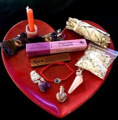 Candles, incense, evil eye jewelry, herbs, crystal pendant, pendulum, sage smudge