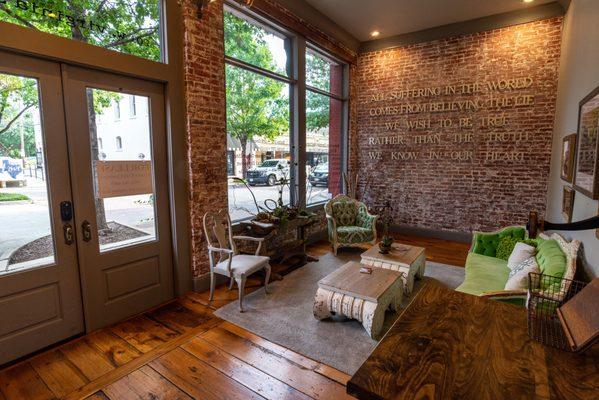 The building is nestled among local shops, cafes, and tree-lined sidewalks, creating a welcoming and accessible environment.