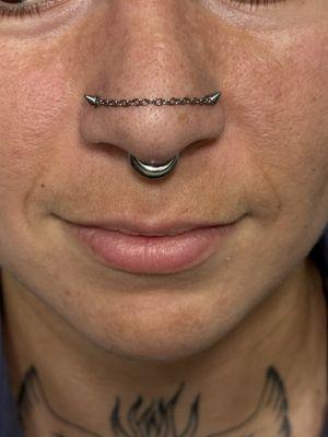 Double nostril piercing with titanium chain