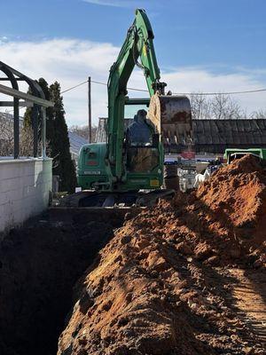 Excavated dirt to expose an existing foundation for repair- Purcellville VA