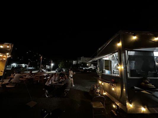 Outside parking lot in the back and tables/chairs between ST and Happy Belly.