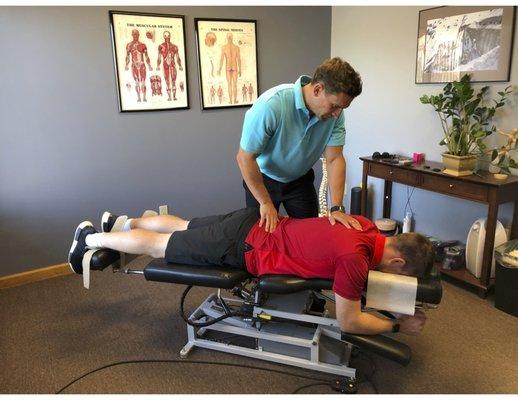 Dr. Michael Welc adjusts a patient in a private chiropractic suite.