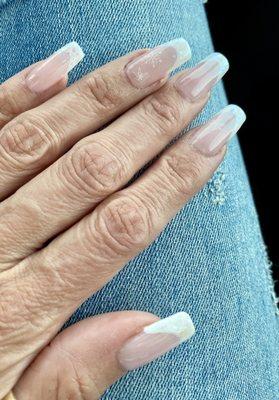 French style nail tips with iridescent glitter on the tips and snowflake accents.