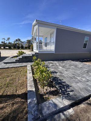 Patio with a planter and stairs to the front door.