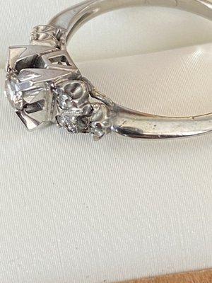 Ham-handed re-sizing cracked setting for small diamond which subsequently fell out and was lost.