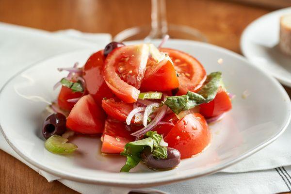 Vine ripe organic tomato salad with red onions, Kalamata, olives, basil, celery, and extra-virgin olive oil