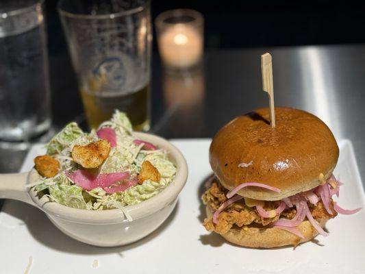 Fried chicken sandwich with a Caesar side salad