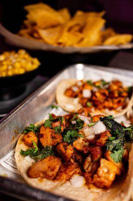 A tray of street tacos topped with onions and cilantro
