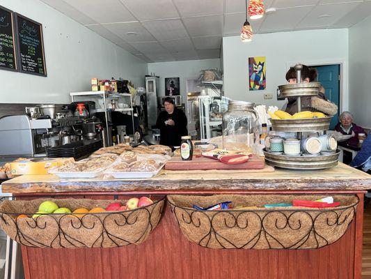 Front display with chips, fresh fruit, muffins, cookies snd local candles.