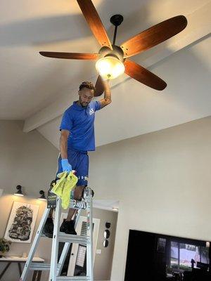 Michael deep cleaning ceiling fan around 20 feet high