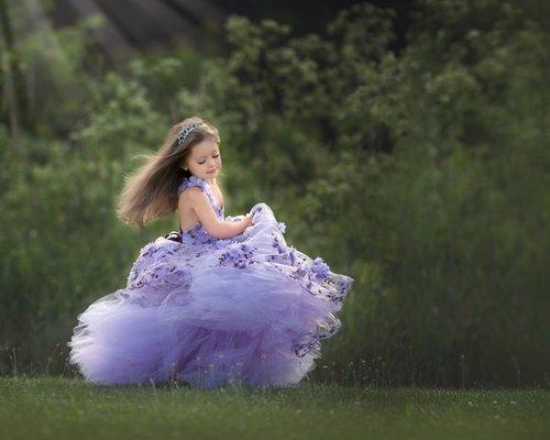 A little princess twirling in her purple dress.