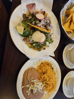 Carne asada and carnitas tacos with rice and beans.