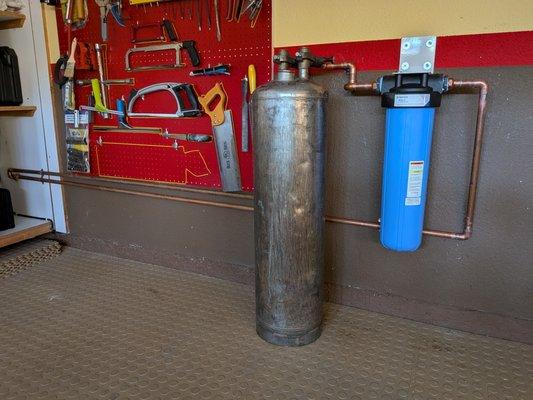 Very clean installation. They installed a portable exchange tank and carbon filter. Routed pipe from outside through garage cabinets.