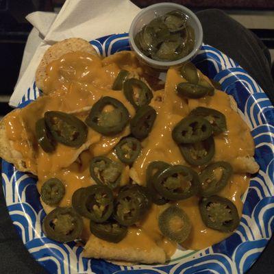 Nachos served on a paper plate with old nacho cheese sauce.