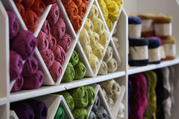 Balls of yarn organized neatly on the shelves.