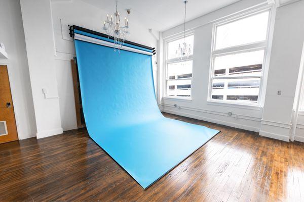 Three motorized extra wide 12-foot seamless backdrops. Colors included are blue, white, and black.